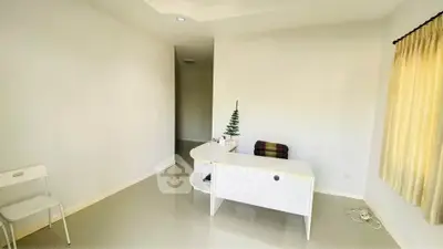 Minimalist study room with white desk and chair, bright natural light