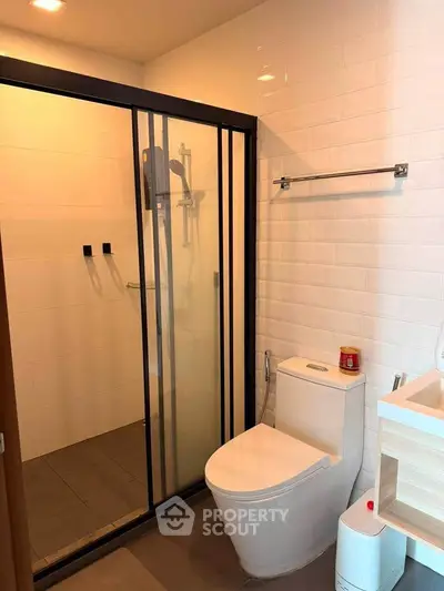 Modern bathroom with glass shower enclosure and sleek fixtures