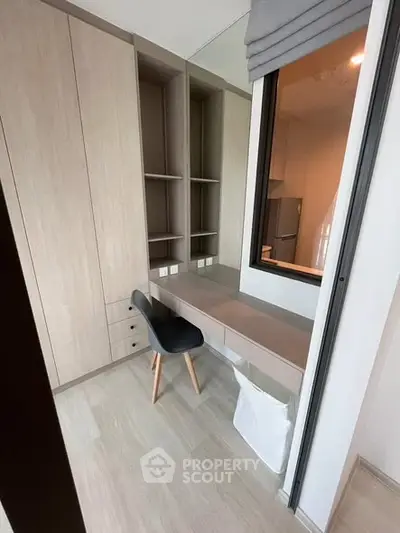 Modern study nook with built-in desk and shelving in a stylish apartment.