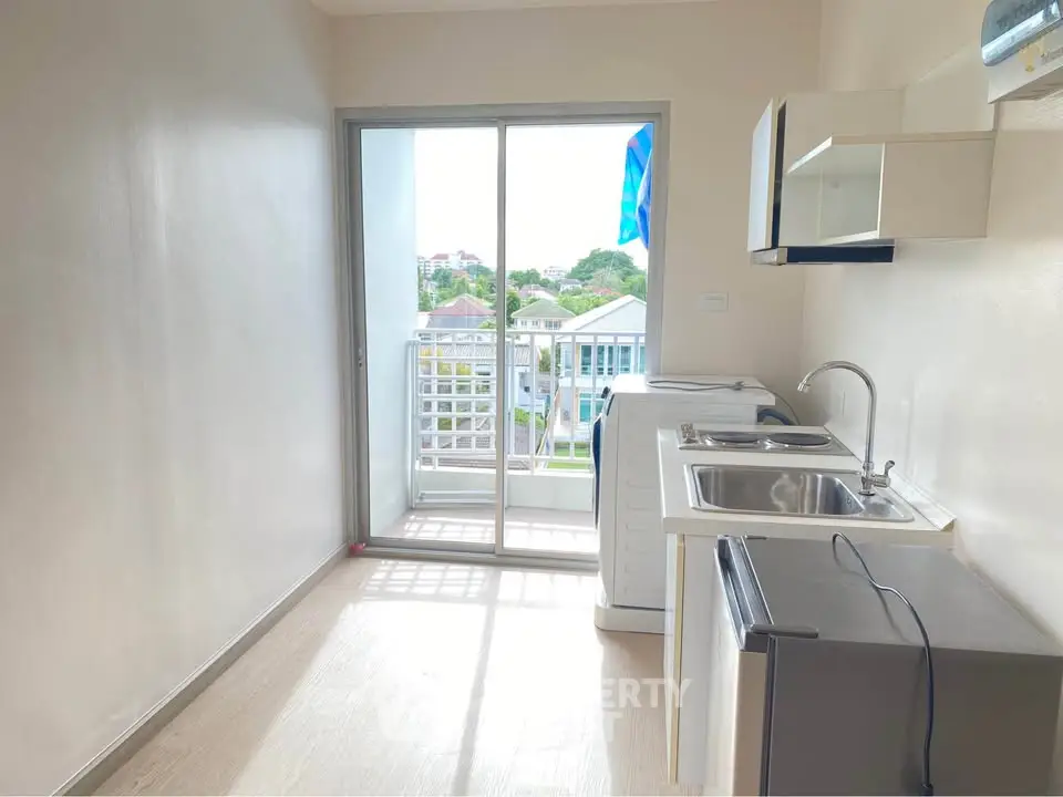 Bright kitchen with balcony view, featuring modern appliances and ample natural light.