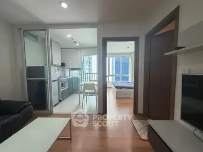 Modern apartment interior with open kitchen and cozy living area, featuring sleek design and natural light.