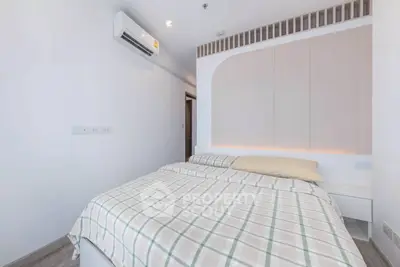 Modern bedroom with stylish decor and air conditioning in a cozy apartment.
