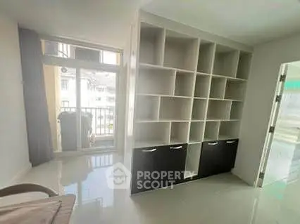 Spacious living room with built-in shelving and balcony access