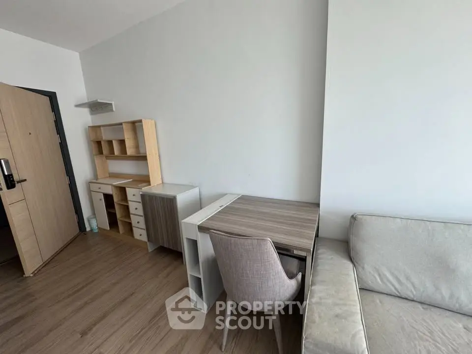 Modern apartment interior with stylish furniture and wooden flooring, featuring a cozy study area and comfortable seating.