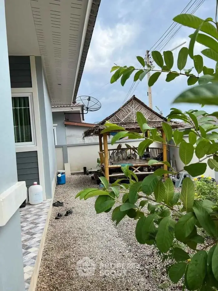 Charming exterior view of a cozy home with a rustic gazebo and lush greenery, perfect for outdoor relaxation.