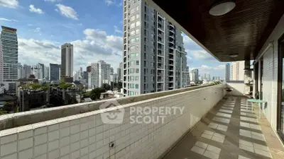 Spacious balcony with stunning city skyline views in modern high-rise building.