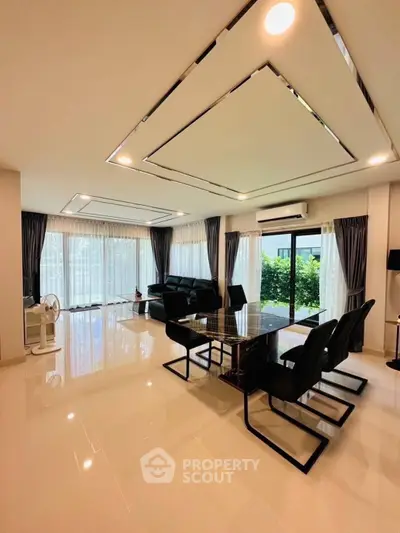 Spacious modern living room with elegant dining area and large windows offering garden views.