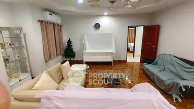 Spacious living room with modern furniture and elegant decor, featuring a glass coffee table and stylish lighting.