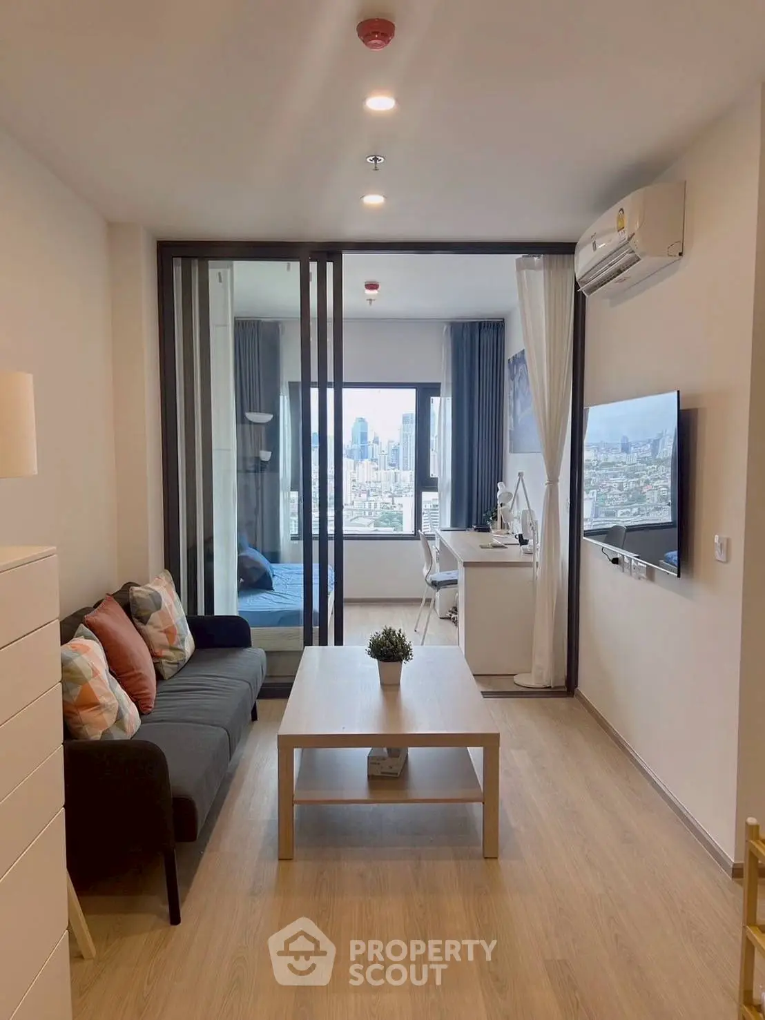 Modern living room with city view, featuring sleek furniture and stylish decor.