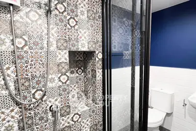 Stylish bathroom with patterned tiles and modern shower enclosure