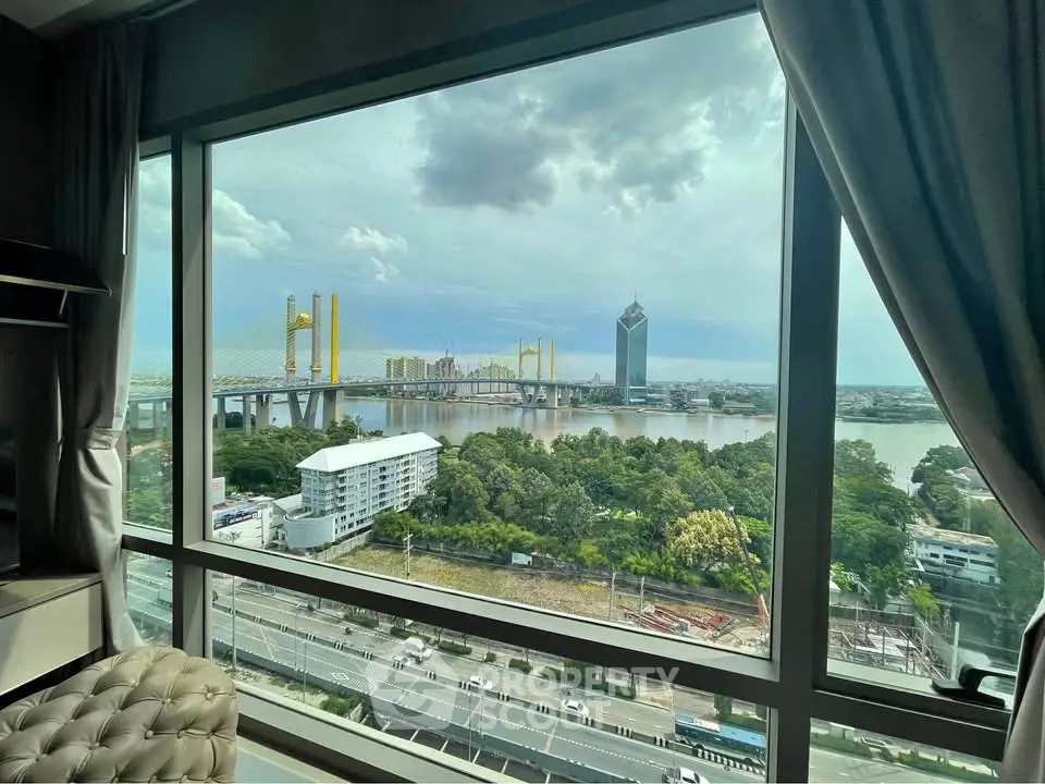 Stunning river view from high-rise apartment window with cityscape and bridge.