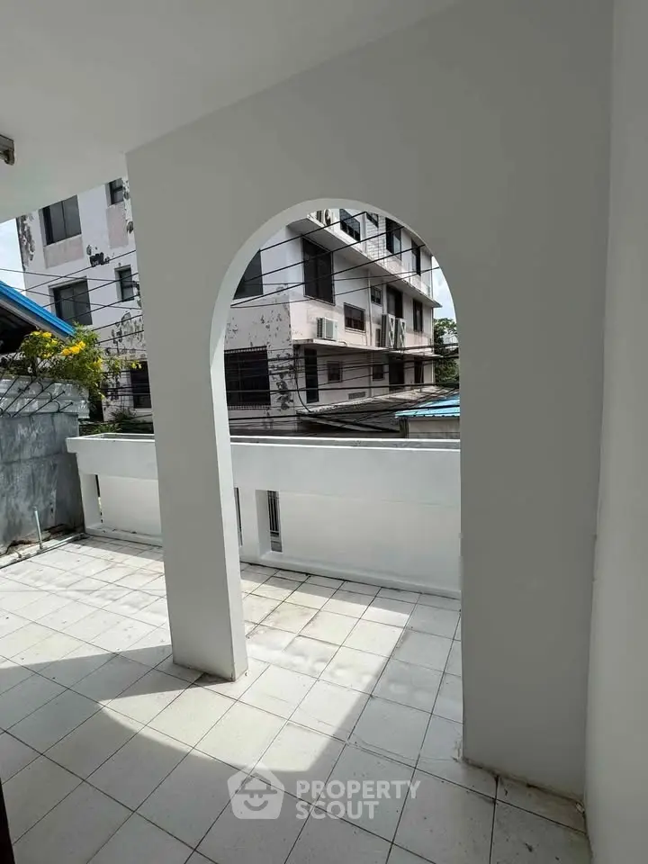 Spacious balcony with modern archway and city view