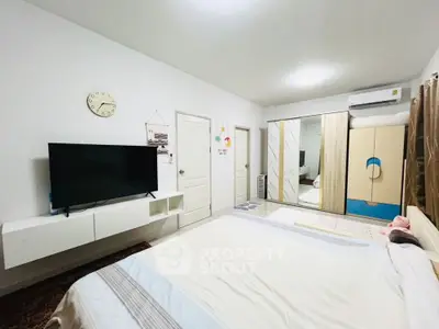 Spacious modern bedroom with TV and mirrored wardrobe