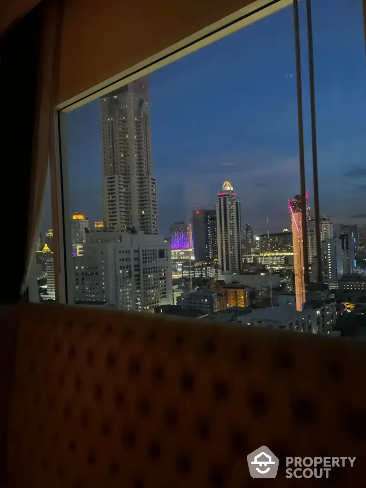 Stunning cityscape view from a high-rise apartment window at dusk.