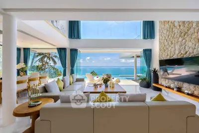 Luxurious open-plan living room with stunning ocean view and modern decor.
