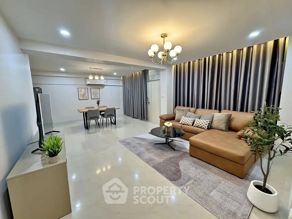 Spacious modern living room with elegant decor and open dining area, perfect for family gatherings.