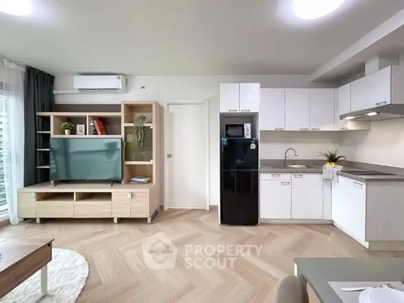 Modern open-plan living room and kitchen with sleek appliances and stylish decor.