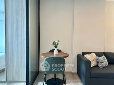 Modern living room with cozy sofa and stylish dining area in open layout apartment.