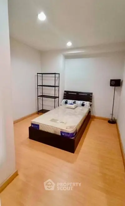 Spacious bedroom with minimalist design and wooden flooring