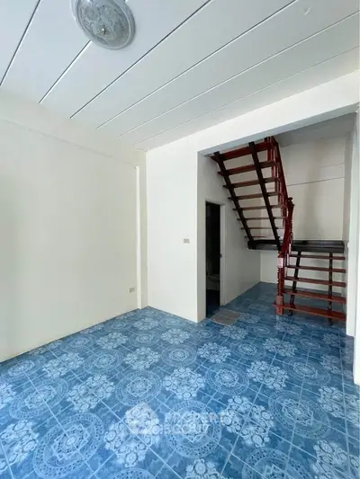 Charming interior with unique blue patterned flooring and elegant wooden staircase, perfect for modern living.