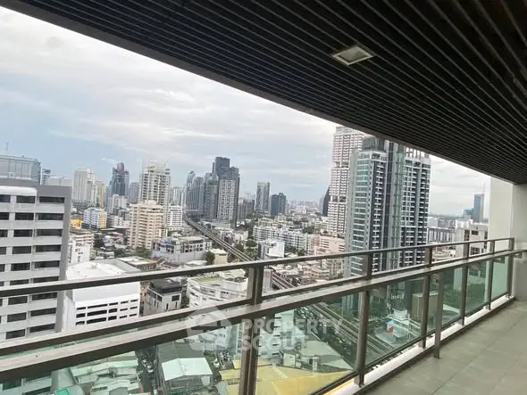 Stunning cityscape view from a modern high-rise balcony with glass railing.