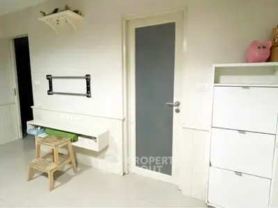 Minimalist interior with white storage and door, ideal for modern living spaces.