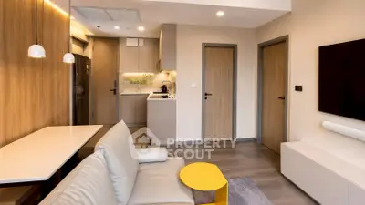 Modern living room with open kitchen, sleek design, and cozy ambiance in a contemporary apartment.