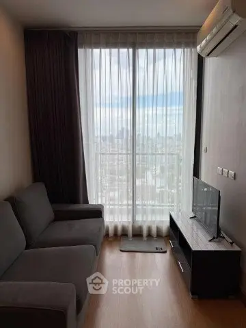 Cozy living room with city view, featuring a sleek sofa and modern entertainment unit.