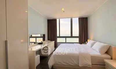 Luxurious bedroom with ocean view, modern furnishings, and ample natural light.