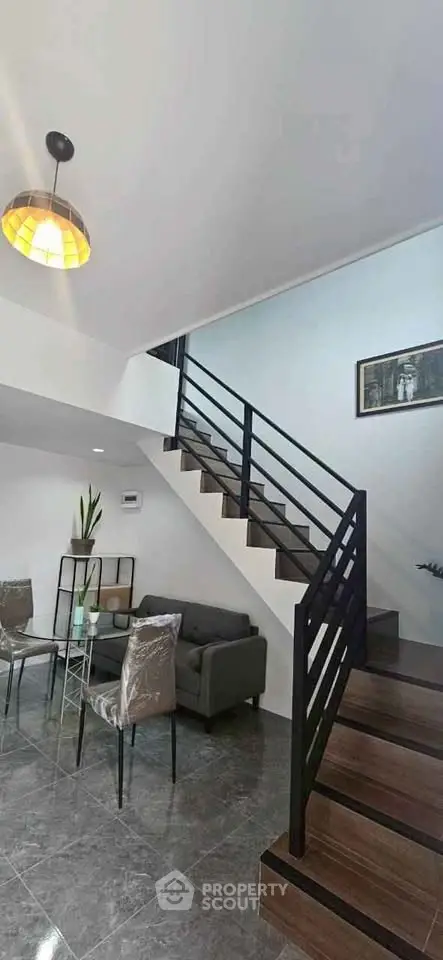 Modern interior with stylish staircase and cozy living area, perfect for contemporary living.