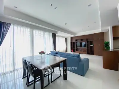 Spacious modern living room with large windows and elegant dining area