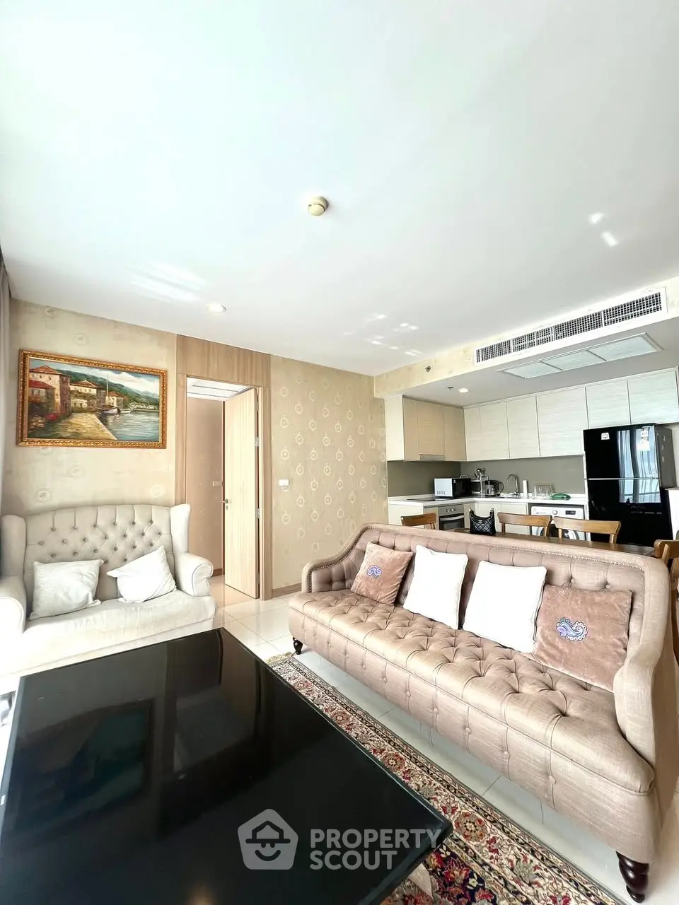 Spacious living room with elegant furniture and modern kitchen in open layout apartment.