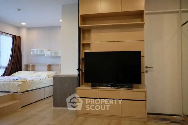 Modern bedroom with built-in TV unit and cozy bed setup