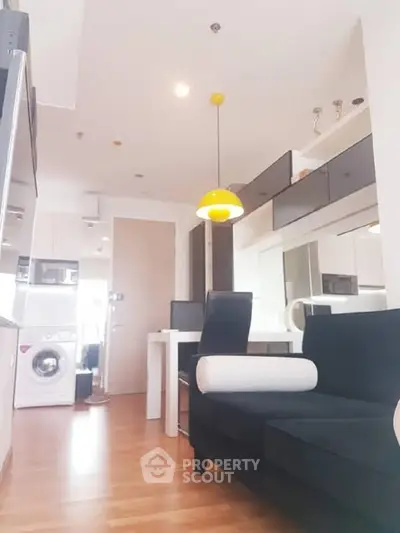 Modern apartment interior with sleek furniture and washing machine, bright and inviting space.