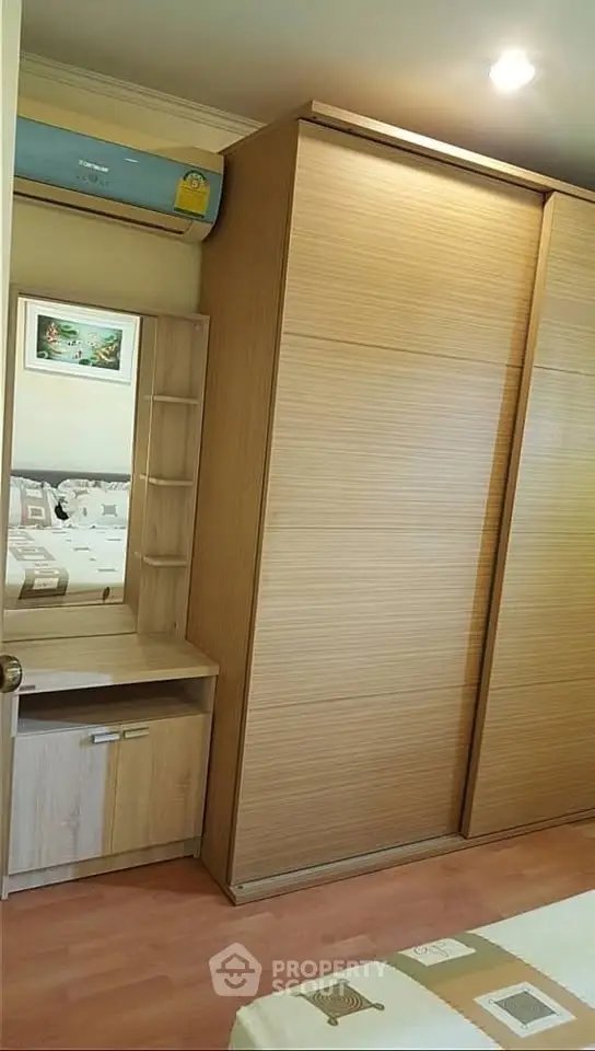 Cozy bedroom with wooden wardrobe and vanity in modern apartment