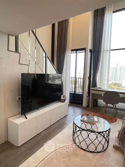 Modern living room with high ceilings, large windows, and stylish furniture in a luxury apartment.