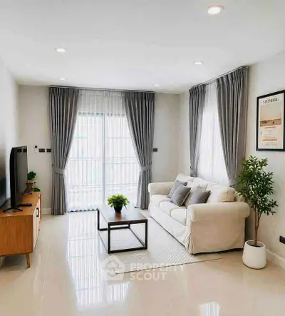 Modern living room with sleek furniture and natural light, featuring a cozy sofa and stylish decor.