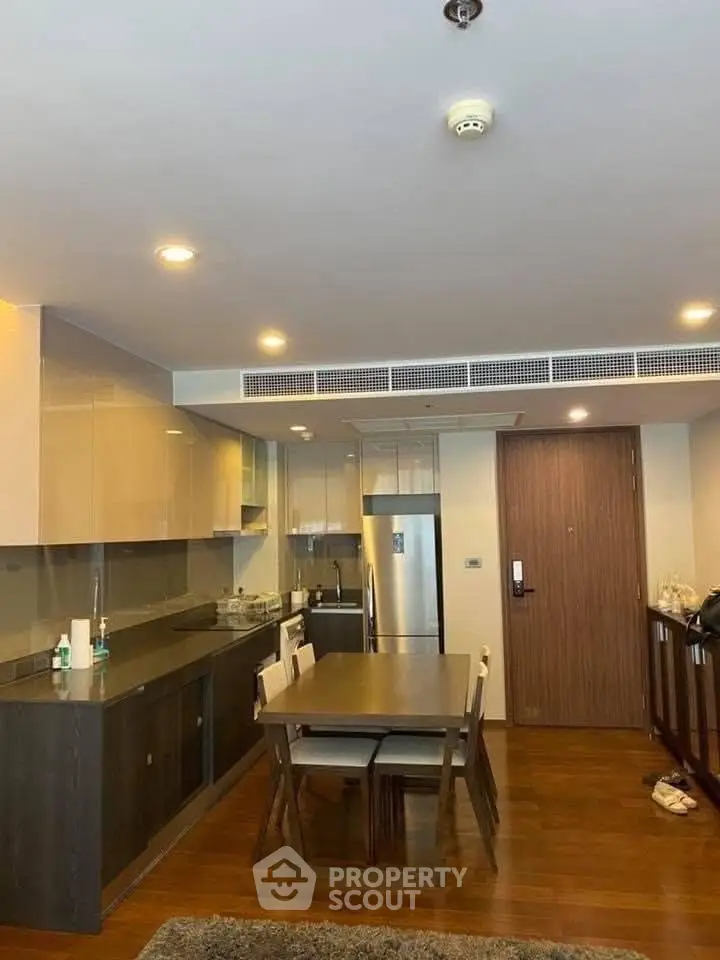 Modern kitchen and dining area with sleek cabinetry and wooden flooring