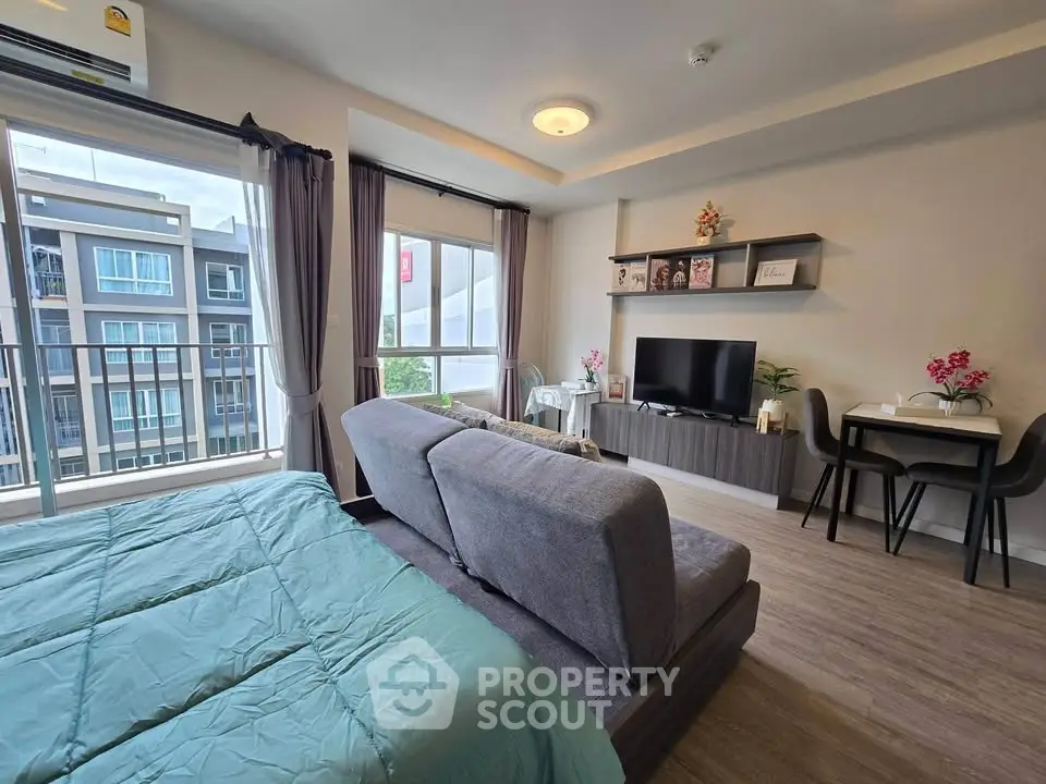Modern studio apartment with cozy living area and large windows