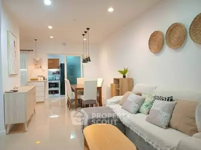 Modern living room with stylish decor and open layout leading to dining area and kitchen.
