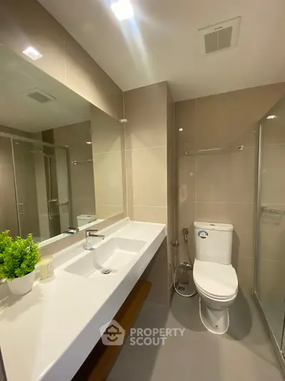 Modern bathroom with sleek fixtures and large mirror in contemporary apartment