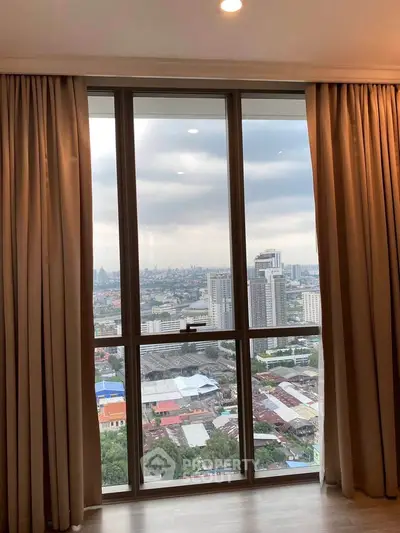 Stunning high-rise apartment view with floor-to-ceiling windows overlooking cityscape.