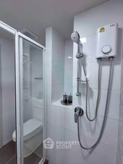 Modern bathroom with sleek shower and water heater, featuring a glass-enclosed shower area.