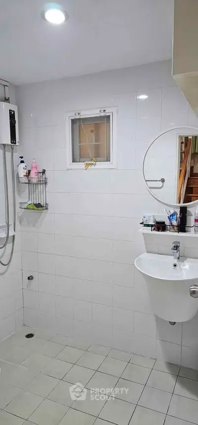 Modern bathroom with white tiles and round mirror