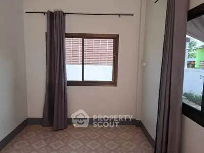 Spacious empty room with large window and elegant curtains, perfect for customization.