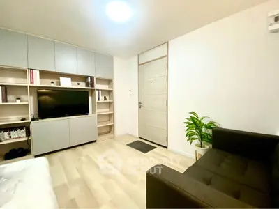 Modern living room with sleek storage, cozy sofa, and stylish decor in a bright apartment.
