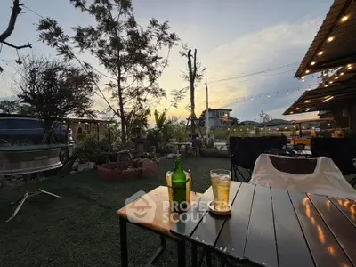 Charming outdoor garden area with cozy seating and ambient lighting, perfect for relaxation and gatherings.