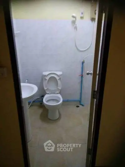 Compact bathroom with essential fixtures including toilet and shower, ideal for small spaces.