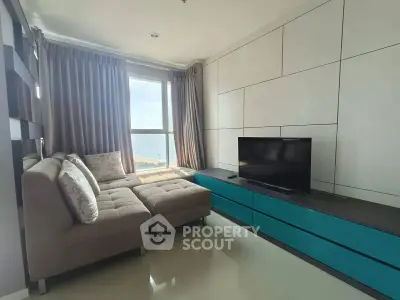 Modern living room with ocean view, stylish sectional sofa, and sleek entertainment unit.