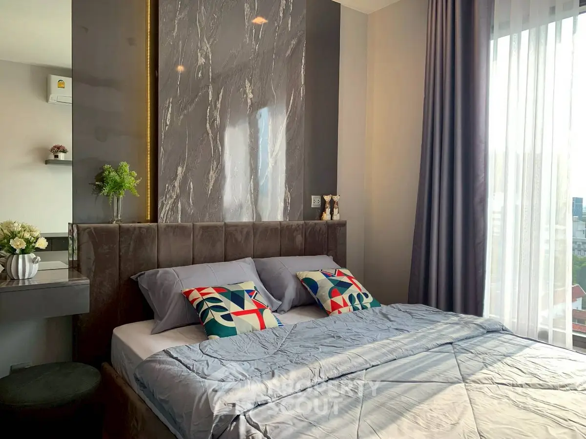 Luxurious bedroom with modern decor and large window offering natural light.